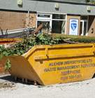 a yellow skip full of waste in an outdoor area
