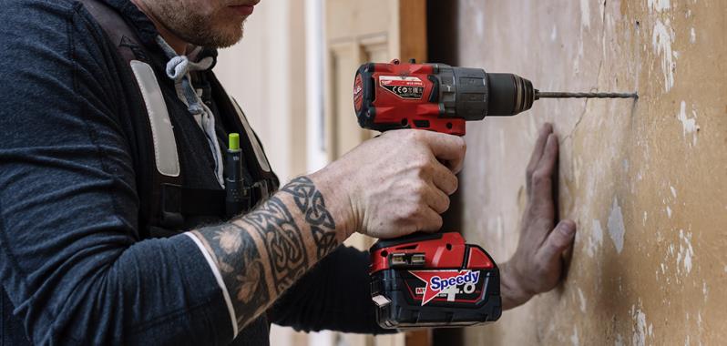 a person using a Milwaukee hammer drill to drill into a Solid Wall