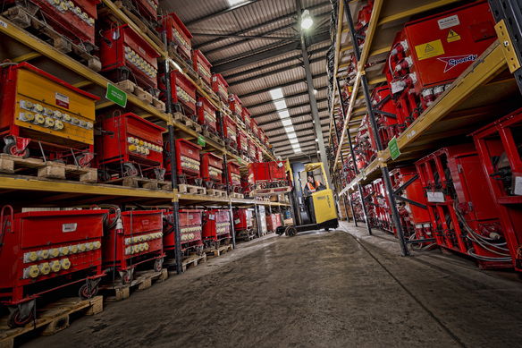 a photo showing inside a warehouse between 2 rows of equipment