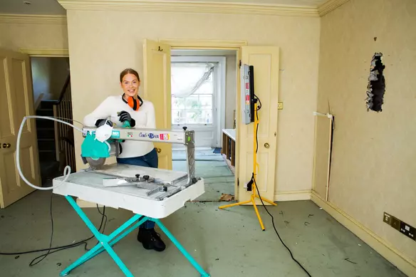 a women using a tile cutter 