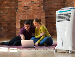 2 people sitting comfortably in a room using a white air conditioner