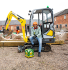 Person sitting on a mini digger at a construction site preparing ground for a pond.