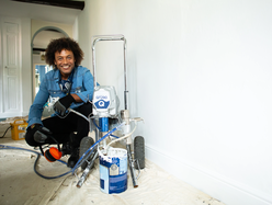a man using a paint sprayer to paint his furniture