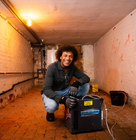 a man using the cube dehumidifier by Speedy in a basement