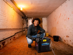 a man using the cube dehumidifier by Speedy in a basement