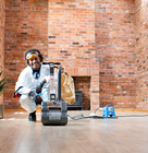 a man using a floor sander in his house