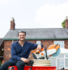 a man sitting next to a cut off saw