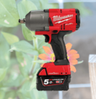Red and black Milwaukee cordless impact wrench displayed against a background of a garden trellis