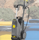 Pressure washer placed in front of outdoor wheelie bins ready for cleaning.