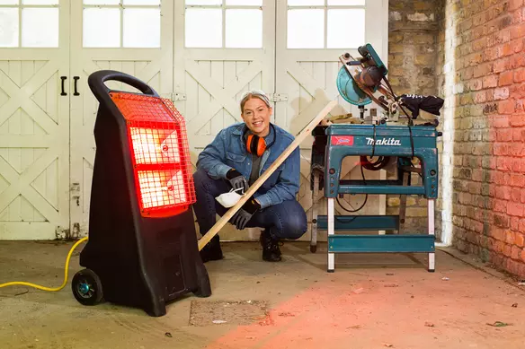 a lady using a portable heater indoor