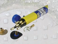 Drain cleaning kit with yellow tube and multiple brass fittings displayed on a concrete surface.