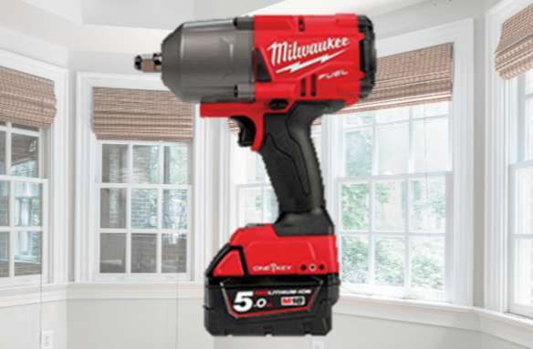 Red Milwaukee cordless impact wrench displayed in a bright room with white-framed windows and woven blinds.