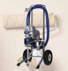 An interior wall being painted with a roller behind an airless paint sprayer.