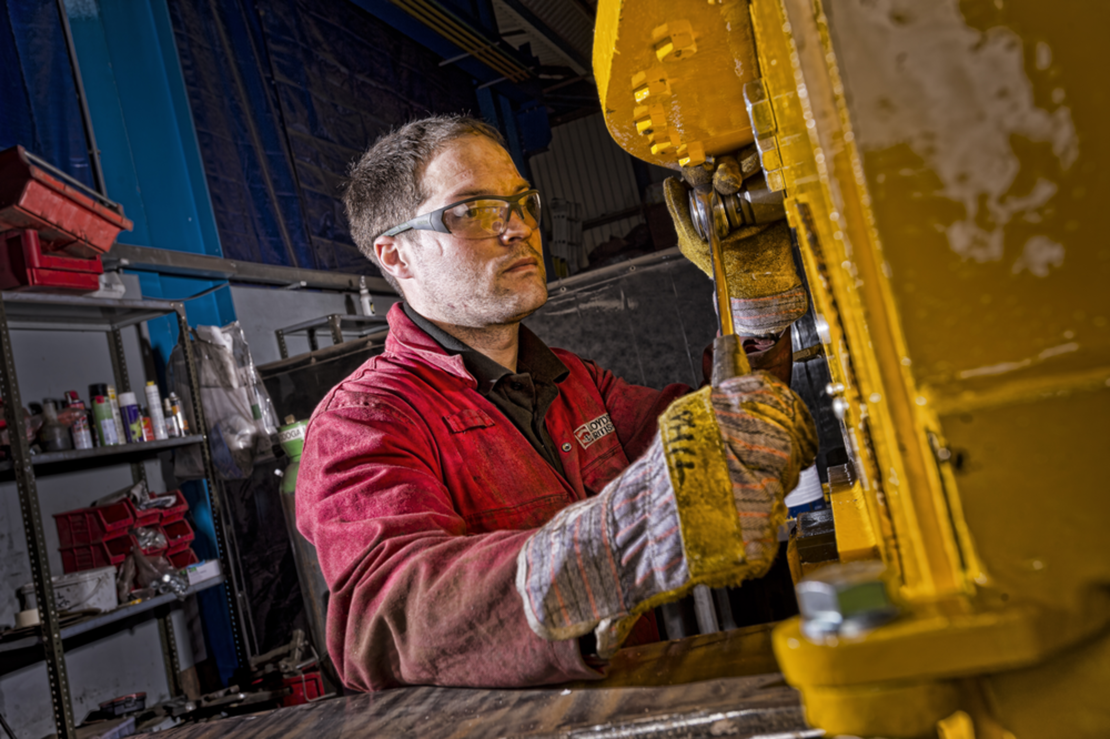 Lloyds British engineer in a red uniform operating the equipment 