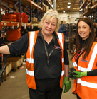 2 speedy staff standing in a warehouse surrounded by equipment
