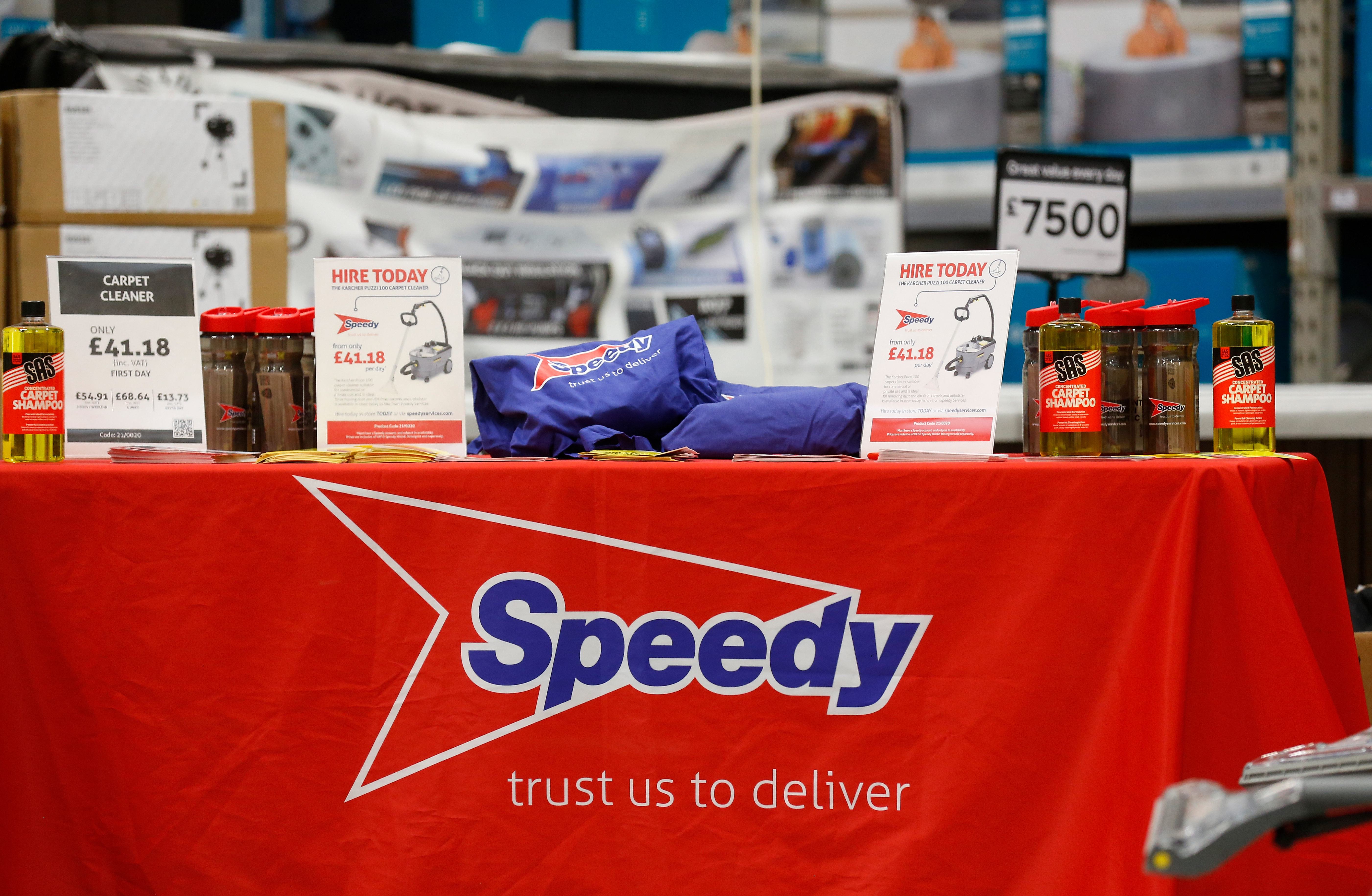 Speedy display table with promotional hire information, carpet cleaner products, and branded merchandise.