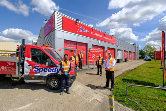 Speedy staff standing in front of Reading depot with a red speedy truck