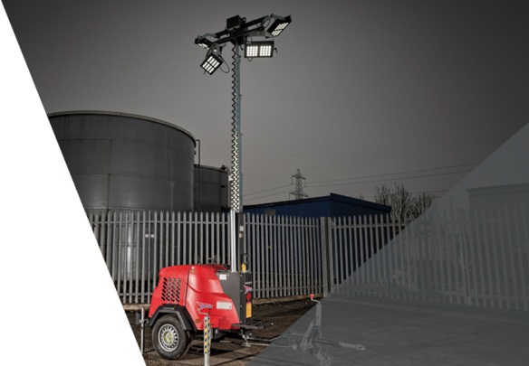 Red portable lighting tower with extended mast and LED floodlights, positioned outdoors near industrial tanks and fencing.