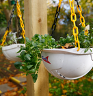 Creative hanging planters made from Speedy hard hats filled with spring flowers.