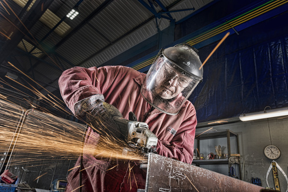 a worker in protective clothes using a welding equipment