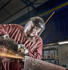 a worker in protective clothes using a welding equipment