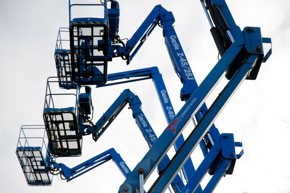 Powered access boom lifts from Speedy Hire lined up for safe working at height