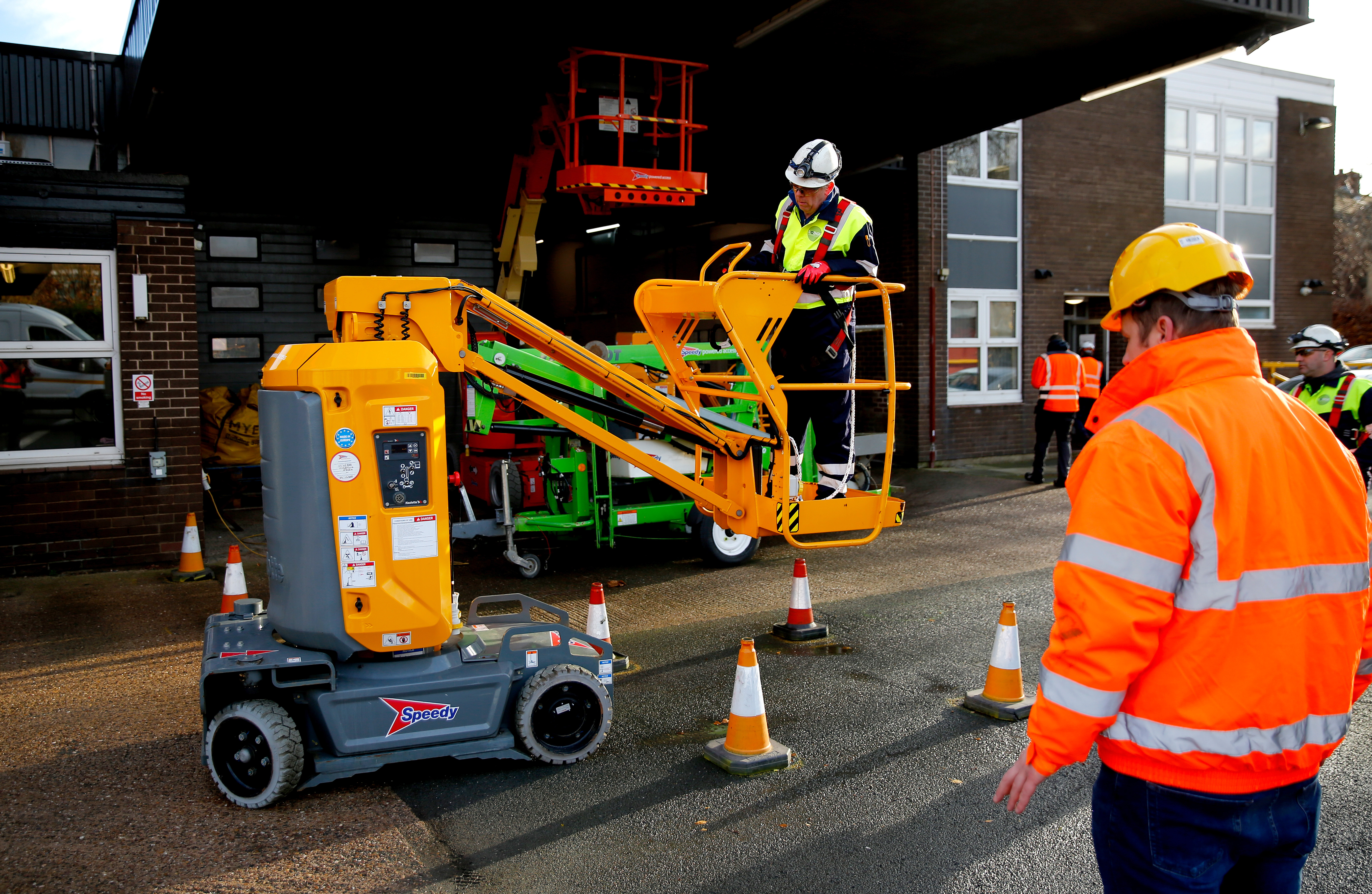 a worker operating an orange mobile elevating work platform