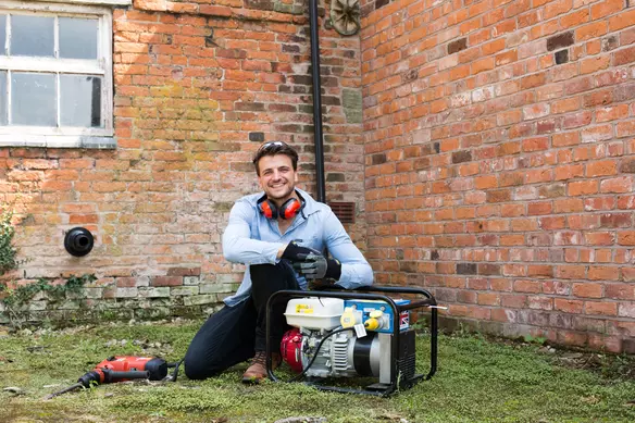 a man using a generator in his garden