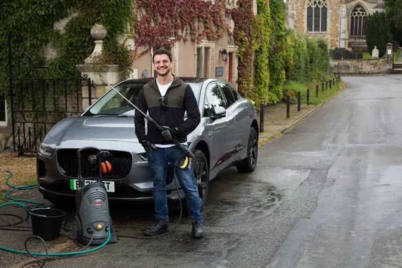 a man using a pressure washer to clean his car