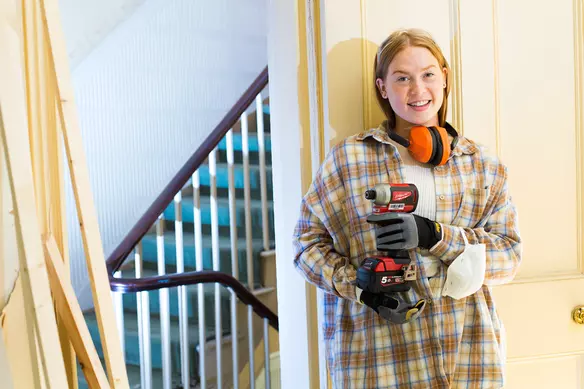 a women holding an impact driver in a DIY project