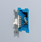 Partially installed light switch fitted into a blue electrical wall box.