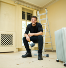 An oil‑filled radiator heater positioned on the floor of a room being renovated
